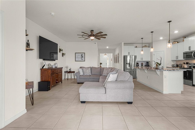 living room with light tile patterned floors, sink, and ceiling fan