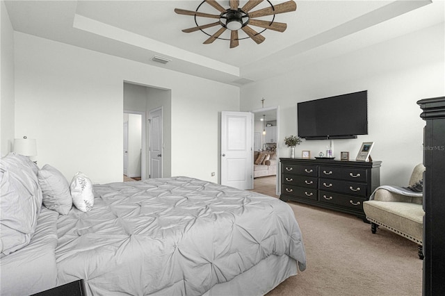 bedroom featuring carpet flooring, ceiling fan, and a tray ceiling