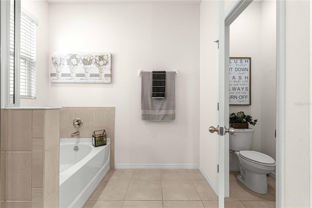 bathroom with tile patterned flooring, a bath, and toilet