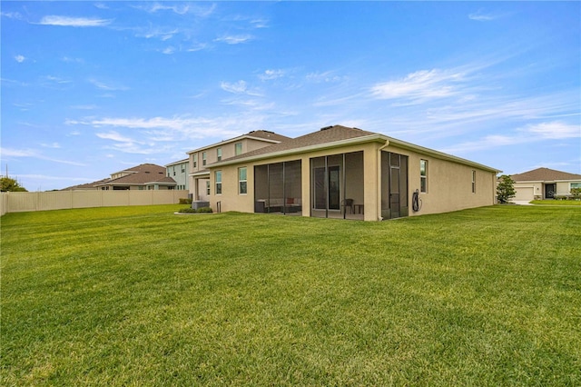 back of property with a yard and a sunroom