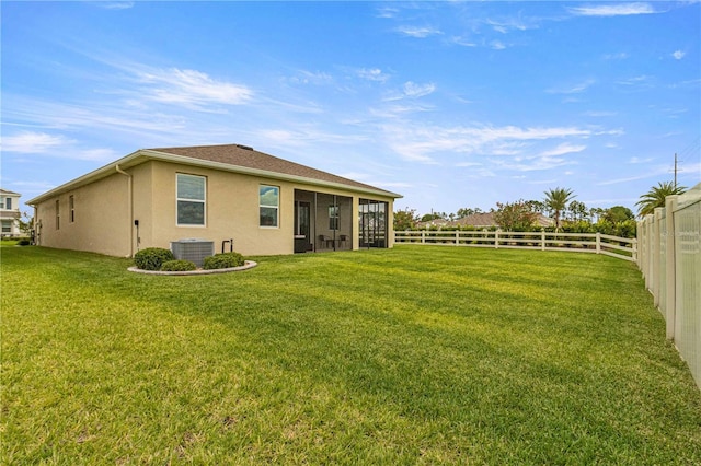 back of property with a yard and central air condition unit