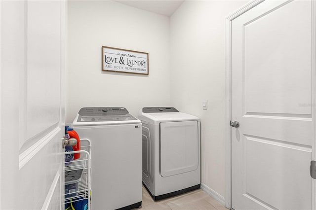 laundry area with washing machine and dryer and light tile patterned floors