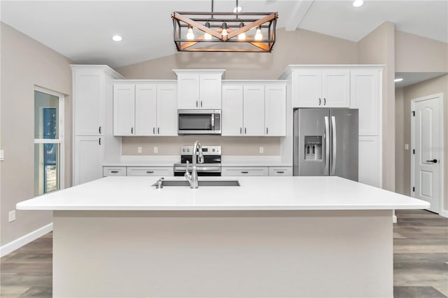 kitchen with a kitchen island with sink, dark wood-type flooring, vaulted ceiling with beams, appliances with stainless steel finishes, and white cabinetry