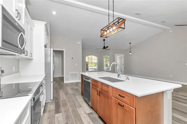 kitchen with white cabinetry, sink, ceiling fan, stainless steel appliances, and a kitchen island with sink