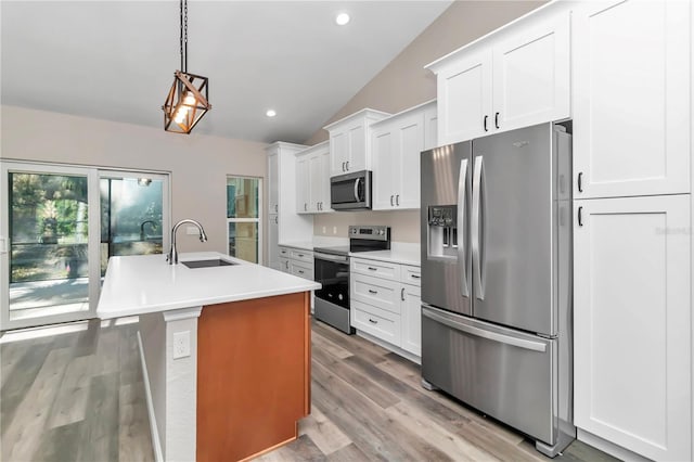 kitchen featuring a kitchen island with sink, white cabinets, sink, hanging light fixtures, and appliances with stainless steel finishes