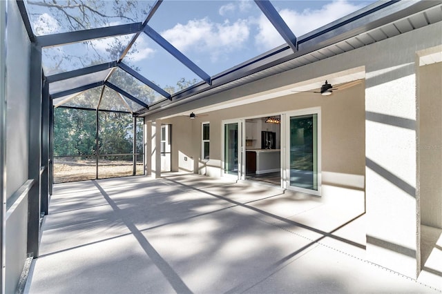 unfurnished sunroom featuring vaulted ceiling with beams and ceiling fan