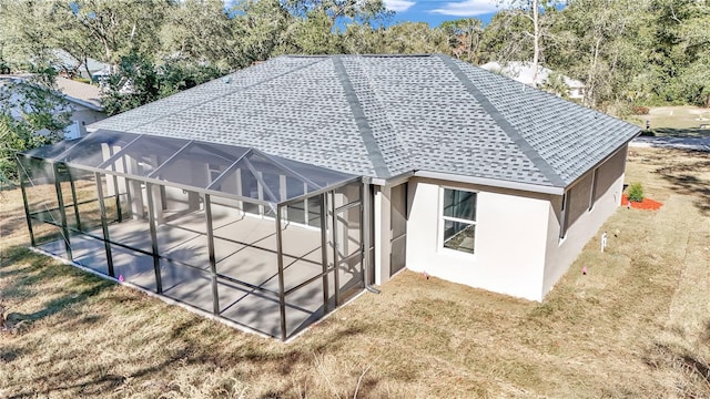 back of property with a lanai and a lawn