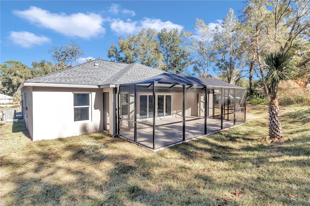 back of property with glass enclosure, a yard, a patio, and central AC