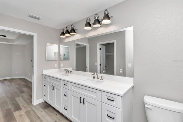 bathroom with hardwood / wood-style floors, vanity, and toilet