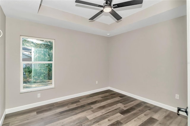 spare room with a raised ceiling, ceiling fan, and hardwood / wood-style floors