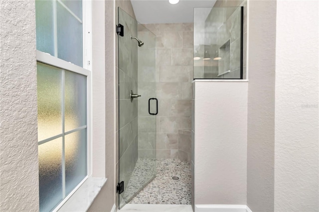 bathroom with a shower with door