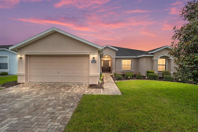 ranch-style house featuring a garage and a yard