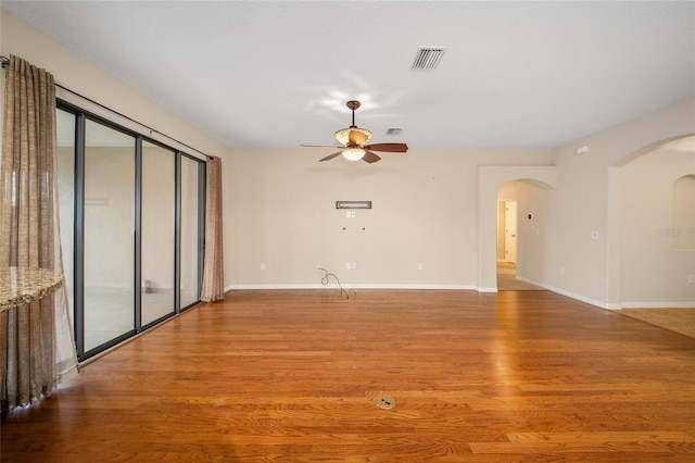 unfurnished room featuring wood-type flooring, ceiling fan, and plenty of natural light