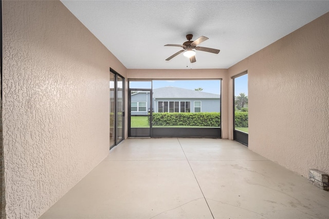 unfurnished sunroom with ceiling fan