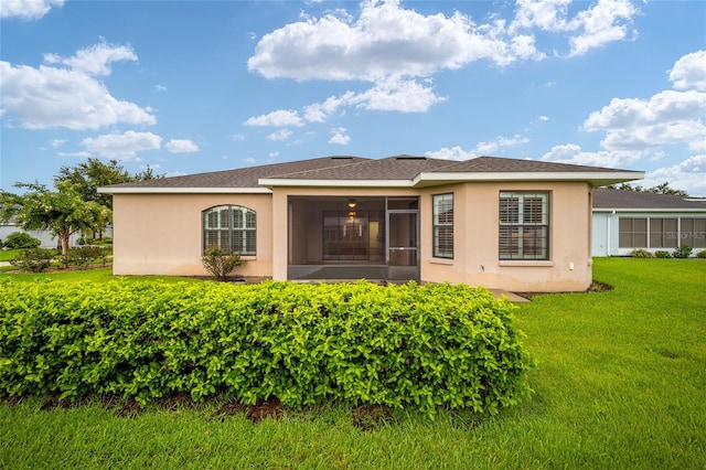 back of property with a yard and a sunroom