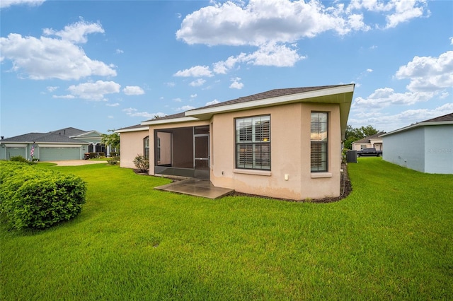 back of property featuring a garage and a lawn