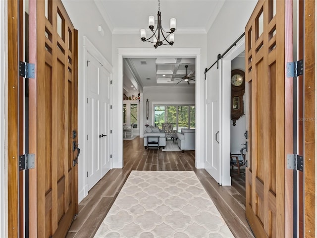 foyer featuring a barn door, dark hardwood / wood-style flooring, ornamental molding, and coffered ceiling