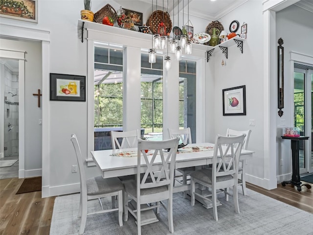 dining space with ornamental molding, plenty of natural light, and hardwood / wood-style floors