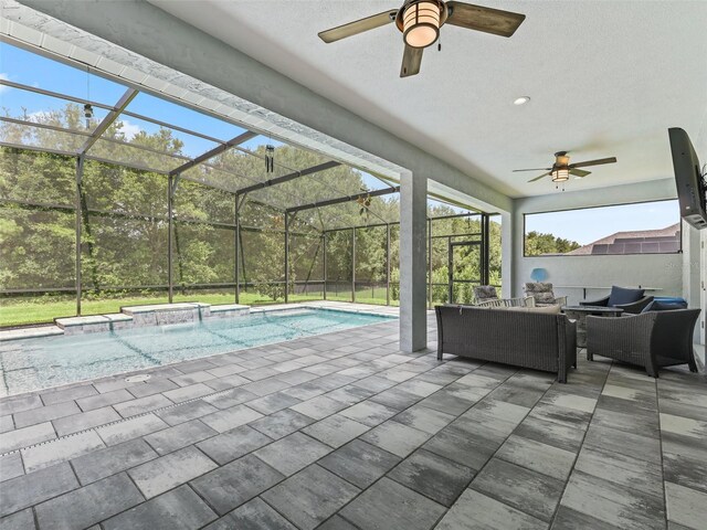 view of pool with an outdoor living space, a patio area, a lanai, and ceiling fan