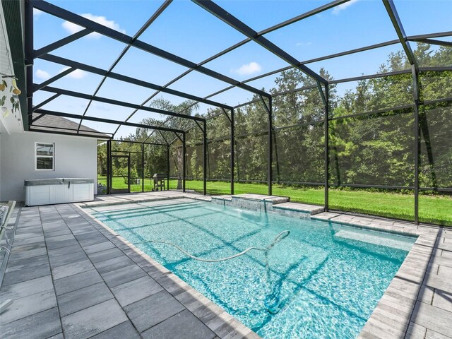 view of pool featuring pool water feature, a patio area, and a lanai