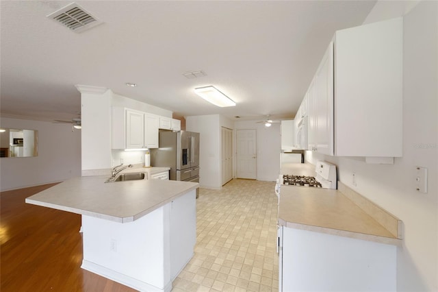 kitchen featuring high end fridge, ceiling fan, kitchen peninsula, and white cabinets