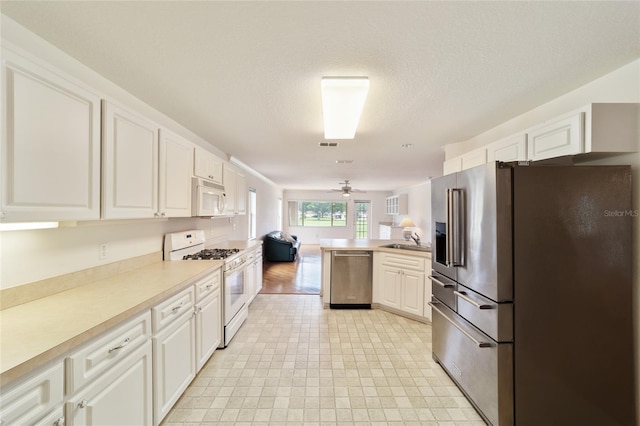 kitchen featuring white cabinetry, appliances with stainless steel finishes, ceiling fan, and kitchen peninsula