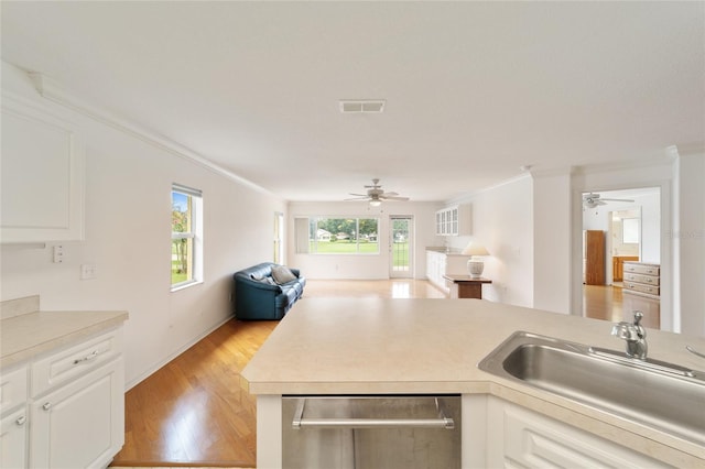 kitchen featuring ornamental molding, sink, stainless steel dishwasher, and white cabinets