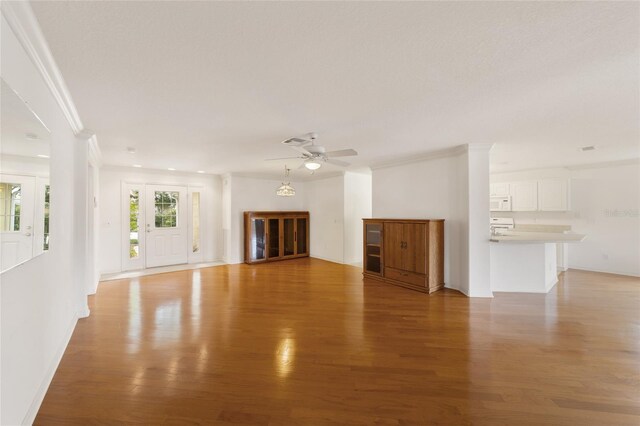 unfurnished living room featuring crown molding, hardwood / wood-style floors, and ceiling fan