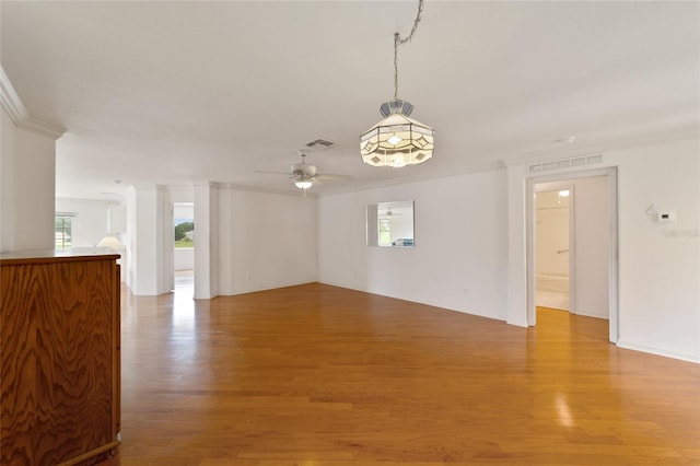 unfurnished living room with ceiling fan, ornamental molding, and light hardwood / wood-style floors