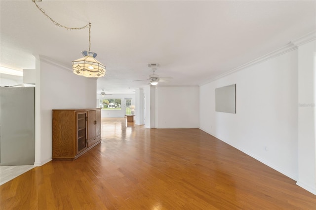 unfurnished room with hardwood / wood-style flooring, crown molding, and ceiling fan