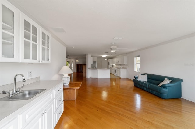 kitchen featuring sink, light hardwood / wood-style flooring, ceiling fan, white cabinets, and white range with gas cooktop