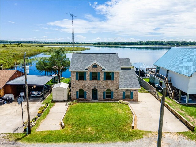 exterior space with a water view, a front yard, and a storage shed