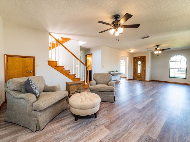 living room with a healthy amount of sunlight, a textured ceiling, ceiling fan, and hardwood / wood-style floors