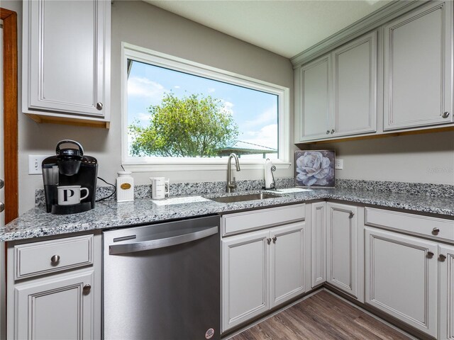 kitchen featuring sink, dishwasher, light stone countertops, and dark wood-type flooring