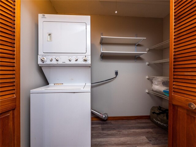 clothes washing area with dark hardwood / wood-style floors and stacked washer / dryer