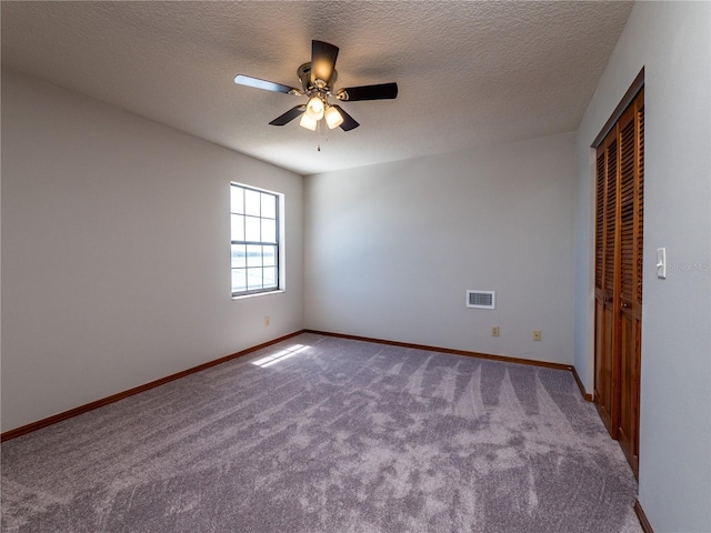 carpeted empty room featuring a textured ceiling and ceiling fan