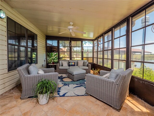 sunroom / solarium featuring a healthy amount of sunlight, ceiling fan, and wood ceiling