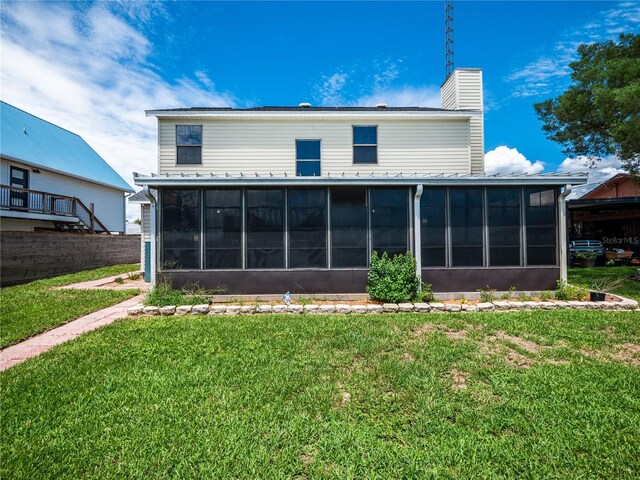 back of house with a yard and a sunroom