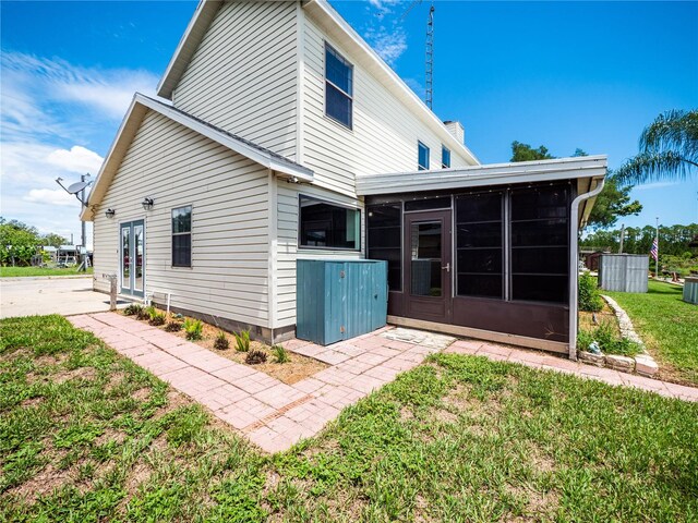 back of property featuring a sunroom and a yard