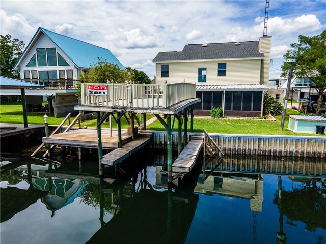 view of dock with a yard and a water view