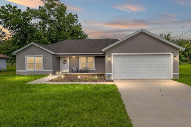 single story home with a garage and a lawn