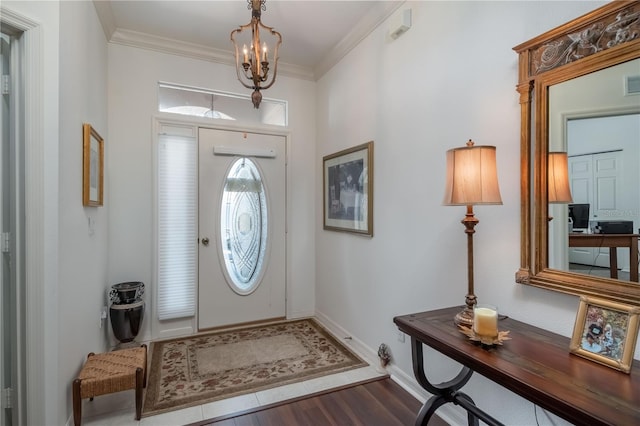 foyer entrance featuring crown molding, an inviting chandelier, and hardwood / wood-style flooring