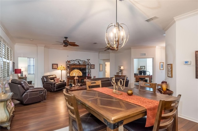 dining room featuring ornamental molding, ceiling fan with notable chandelier, and dark hardwood / wood-style flooring