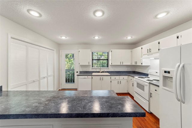 kitchen with sink, white appliances, dark wood-type flooring, a textured ceiling, and white cabinets