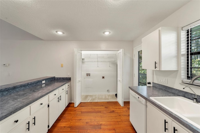 kitchen featuring sink, dishwasher, plenty of natural light, white cabinets, and light wood-type flooring