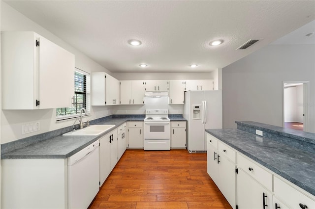 kitchen featuring sink, a textured ceiling, light wood-type flooring, white appliances, and white cabinets