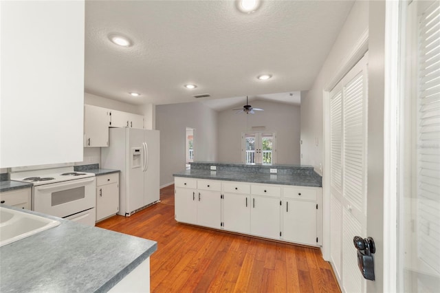 kitchen featuring lofted ceiling, white cabinets, white appliances, and light hardwood / wood-style flooring