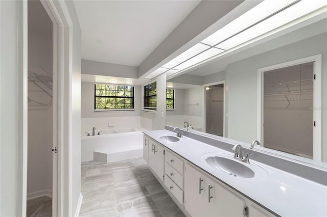 bathroom with a relaxing tiled tub and vanity