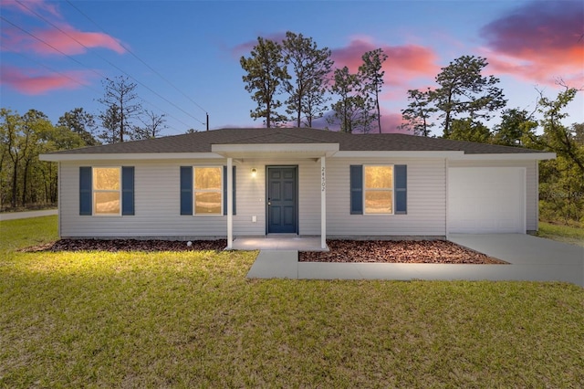 single story home with a garage and a lawn