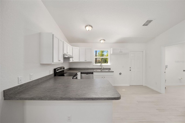 kitchen featuring stainless steel appliances, white cabinets, sink, kitchen peninsula, and lofted ceiling